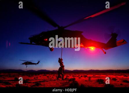 U.S. Air Force soldiers climb into helicopters at sunset during Advanced Guard special operations training exercises at the Holloman Air Force Base April 14, 2014 near Alamogordo, New Mexico. Stock Photo