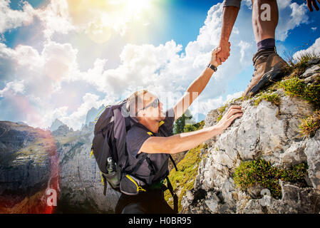 Friendly Hand on the High Mountain Hike. Men Helping Other Hiker by Giving Him Hand. Hiking Theme. Stock Photo
