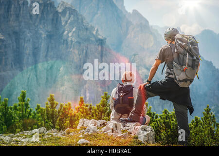 Hiker and Biker on a Trail Enjoying Amazing Mountain Vista. Stock Photo