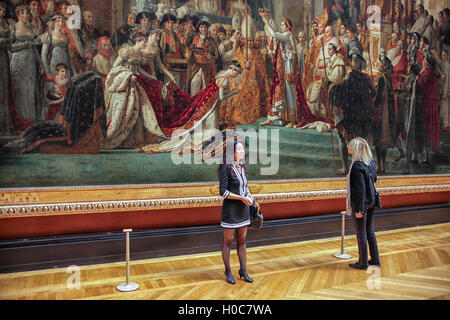 Tourists in front of The Coronation of Napoleon (Le Sacre de Napoléon) in the Louvre museum Stock Photo
