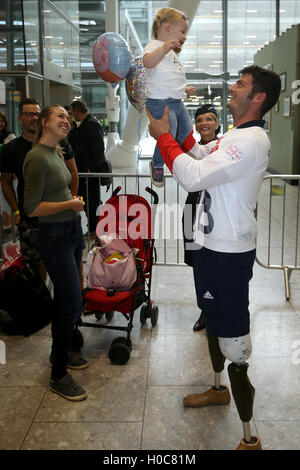 Great Britain's David Henson holding 19th month olf daughter Emily alongside wife Hayley (left) as he arrives back at Heathrow Airport, London. PRESS ASSOCIATION Photo. Picture date: Tuesday September 20, 2016. The Paralympics GB squad arrive back in the UK after collecting 147 medals to finish second in the 2016 Rio Paralympic medal table, surpassing their total of 120 from London 2012. PRESS ASSOCIATION Photo. Photo credit should read: Steve Parsons/PA Wire Stock Photo