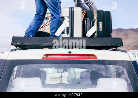 Luggages and Bags arranged on the car roof ready for a trip in sky background Stock Photo
