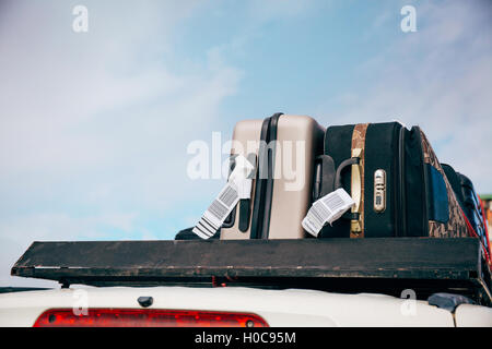 Luggages and Bags arranged on the car roof ready for a trip in sky background Stock Photo
