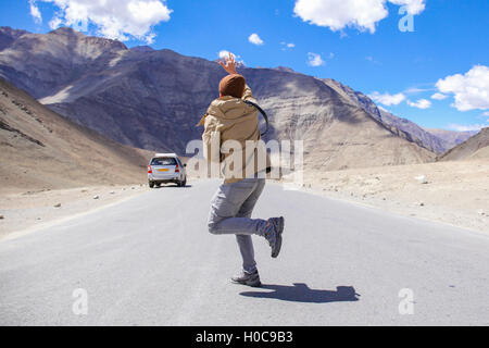 Young male traveler miss and is late for the car in rural area. Stock Photo