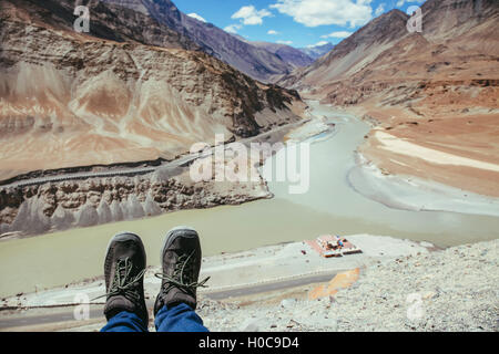 Hiker's boots relaxing and resting his feet on high mountain trekking scene and adventure Stock Photo