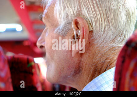 hearing aid in ear of senior man Stock Photo