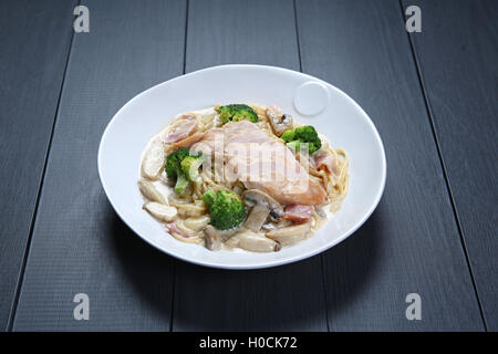 Chicken Carbonara with green broccoli and mushroom on white plate Stock Photo