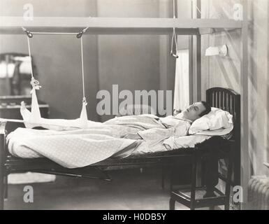 Man with fractured leg sleeping on hospital bed Stock Photo