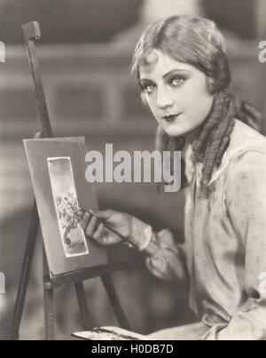 Portrait of an artist with her easel painting a picture of a tree Stock Photo