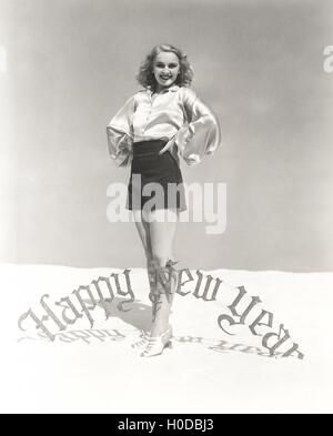 Portrait of smiling woman standing by Happy New Year sign Stock Photo