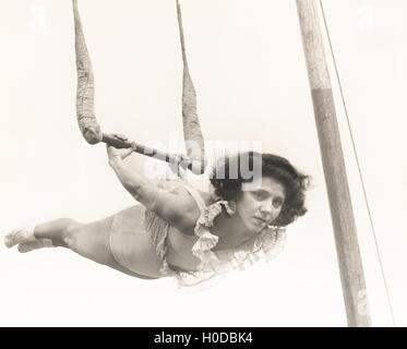 Female trapeze artist in mid-air Stock Photo