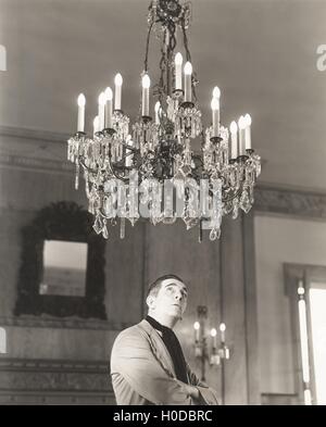 Man staring at chandelier Stock Photo