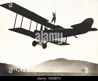 Stunt woman standing on top of biplane Stock Photo