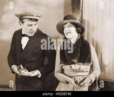 Winking gangster with his gun moll Stock Photo