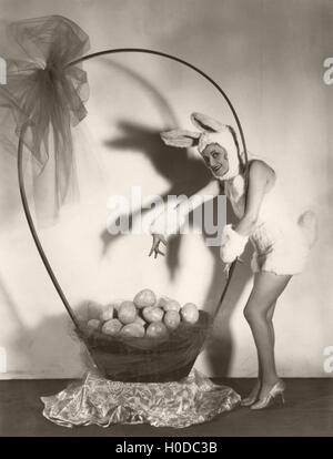 Young happy woman in Easter bunny ears holding plush carrots near ...