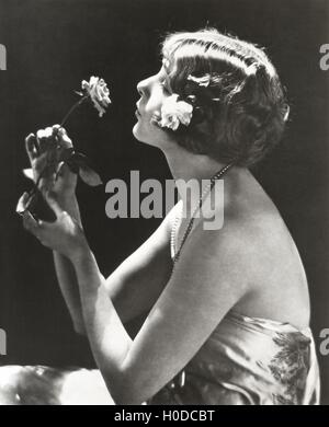 Profile view of young woman smelling flower Stock Photo