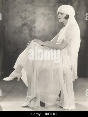 Woman in white chiffon dress and veiled turban Stock Photo