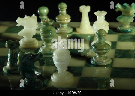 chessboard and alabaster chess on a black background Stock Photo
