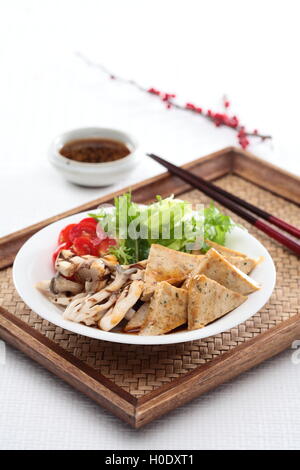 Tofu Salad line with lettuce and sliced tomato on bamboo tray in white background Stock Photo