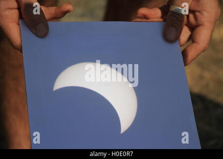Part Annular eclipse, Katavi National Park, Tanzania on 1st September 2016 seen through a telescope and reflected on a card Stock Photo