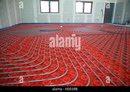 Underfloor heating pipes being laid in new building Stock Photo