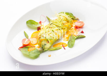 Omelette egg with lettuce, tomatoes and herbs on white plate Stock Photo