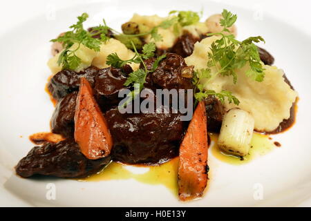 Braised Australian brisket with belgian cocoa mass glazed root vegetables and potato mash Stock Photo