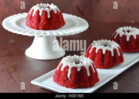 Mini red velvet bundt cakes on white plate on grey background Stock Photo