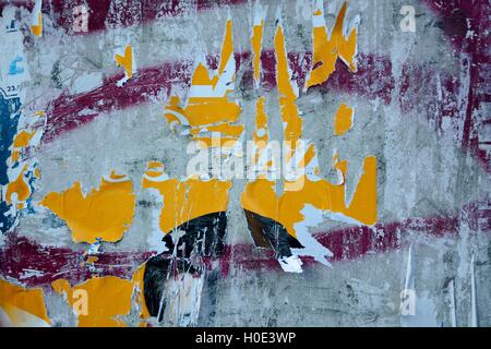 Colorful torn posters on grunge old walls as creative and abstract background Stock Photo