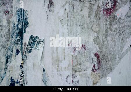 Colorful torn posters on grunge old walls as creative and abstract background Stock Photo