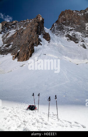 Two pairs trekking poles, glacier and summit Stock Photo