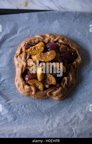 Plum galette on a baking tray before baking Stock Photo