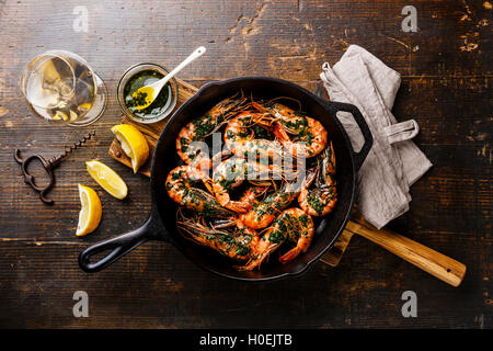 Tiger prawns shrimps roasted on frying grill pan and wine on wooden background Stock Photo