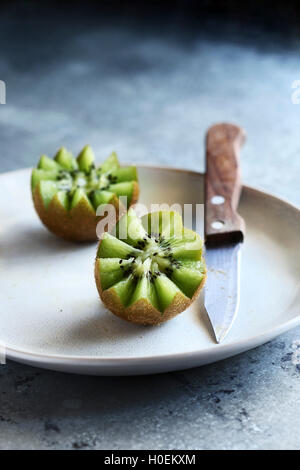 Kiwi fruit cut in flower shape on plate. Stock Photo