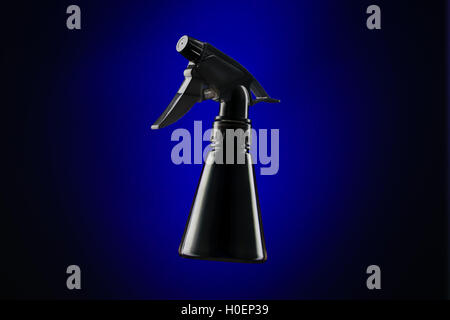 Black mini spray bottle over blue background Stock Photo