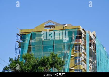 Safety net in the newly built high-rise building. Green grid on building of objects falling from a height. Stock Photo