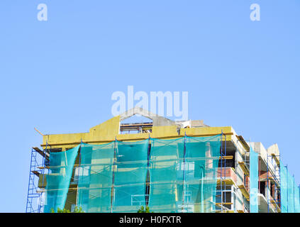 Safety net in the newly built high-rise building. Green grid on building of objects falling from a height. Stock Photo