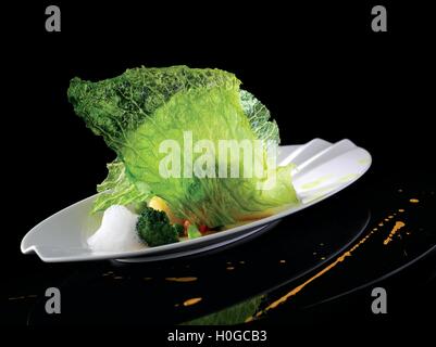 Crispy fried cabbage and sprout vegetables with Argan oil on white platter Stock Photo