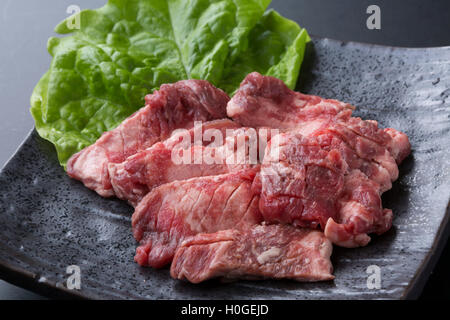 Red meat Haramisuji of cattle with lettuce on black dish Stock Photo