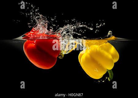 Group of bell pepper falling in water on black Stock Photo