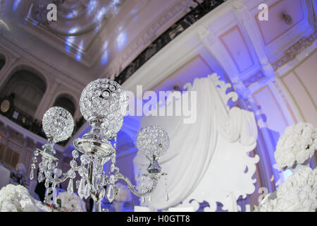 Beautiful restaurant interior table decoration for wedding. Flower . White orchids in vases. luxury candleholders Stock Photo