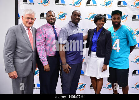 MIAMI, FL - SEPTEMBER 20: BankUnited Senior Executive Vice President Gerry Litrento, Miramar High School Athletic Director Alex Francois, Miramar High School Coach Pierre Senatus, BankUnited Vice President of Community Development & Outreach Katrina Wright and Miami Dolphins Wide Receiver (#14) Jarvis Landry surprise the Miramar Patriots varsity football team prior to the team's practice as part of the 4 Downs for Finance financial literacy program sponsored by BankUnited. Landry share his thoughts on the importance of financial literacy at Miramar High School Media Center on September 20, 201 Stock Photo