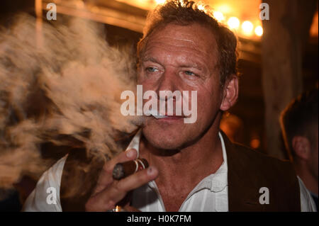 Munich, Germany. 21st Sep, 2016. Actor Ralf Moeller smokes a cigar on the balcony of the Kaeferzelt beer tent at the Oktoberfest in Munich, Germany, 21 September 2016. The 183th Wiesn take place from 17 September 2016 until 3 Octobre 2016. PHOTO: FELIX HOERHAGER/dpa/Alamy Live News Stock Photo