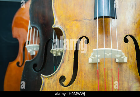 Three double bass detail in a row selective focuse on light brown, black and dark brown one Stock Photo