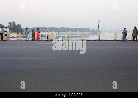 locals waiting for the bus early morning at Tankbund Road in Hyderabad,India Stock Photo