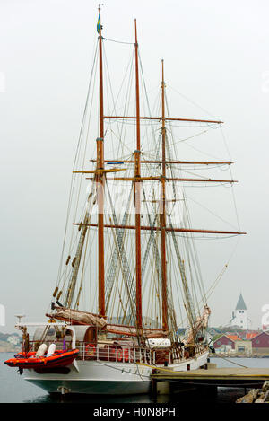 Skarhamn, Sweden - September 9, 2016: Environmental documentary of the sailboat Lady Ellen moored in misty harbor with smiling c Stock Photo