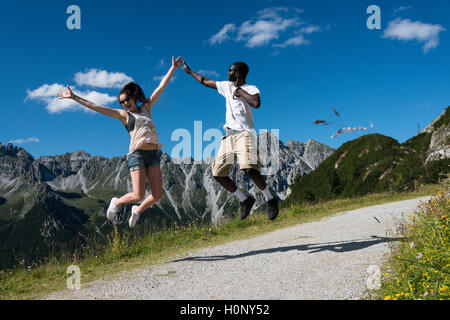 Couple jumping joyfully in the air, hike, Kalkkögel behind, Fulpmes, Stubai Valley, Tyrol, Austria Stock Photo