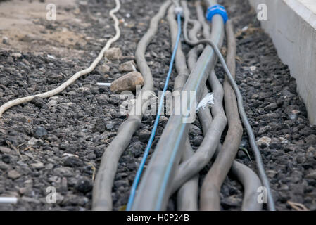 the trail of power electrical cables on the ground Stock Photo