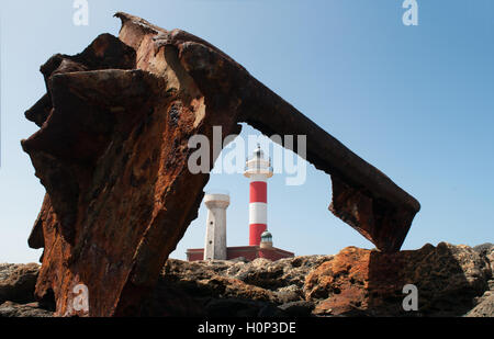 Fuerteventura: the El Toston Lighthouse, whose original structure was opened in 1897 in the northwest of the island, seen through a rusty shipwreck Stock Photo