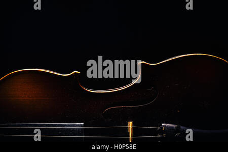Details of an old dusty violin on black background. Stock Photo